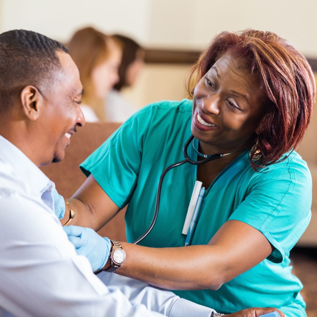 Nurse checking blood pressure for mature African American man